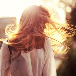 Schwedin mit langen blonden Haaren, Sonnenschein im Hintergrund